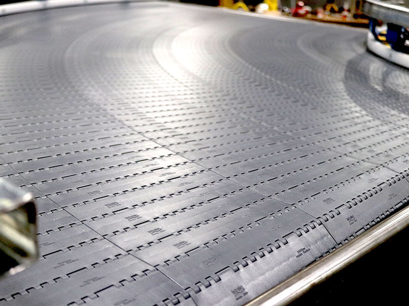 Close-up of modular plastic belt conveyor with curved radius by Webb-Stiles