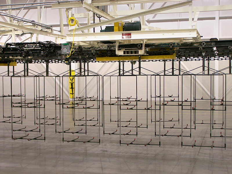 Overhead conveyor system by Webb-Stiles with custom hanging fixtures for material handling