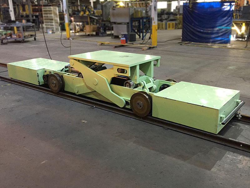 Webb-Stiles low-profile transfer car on embedded rail system for material transport in manufacturing facility