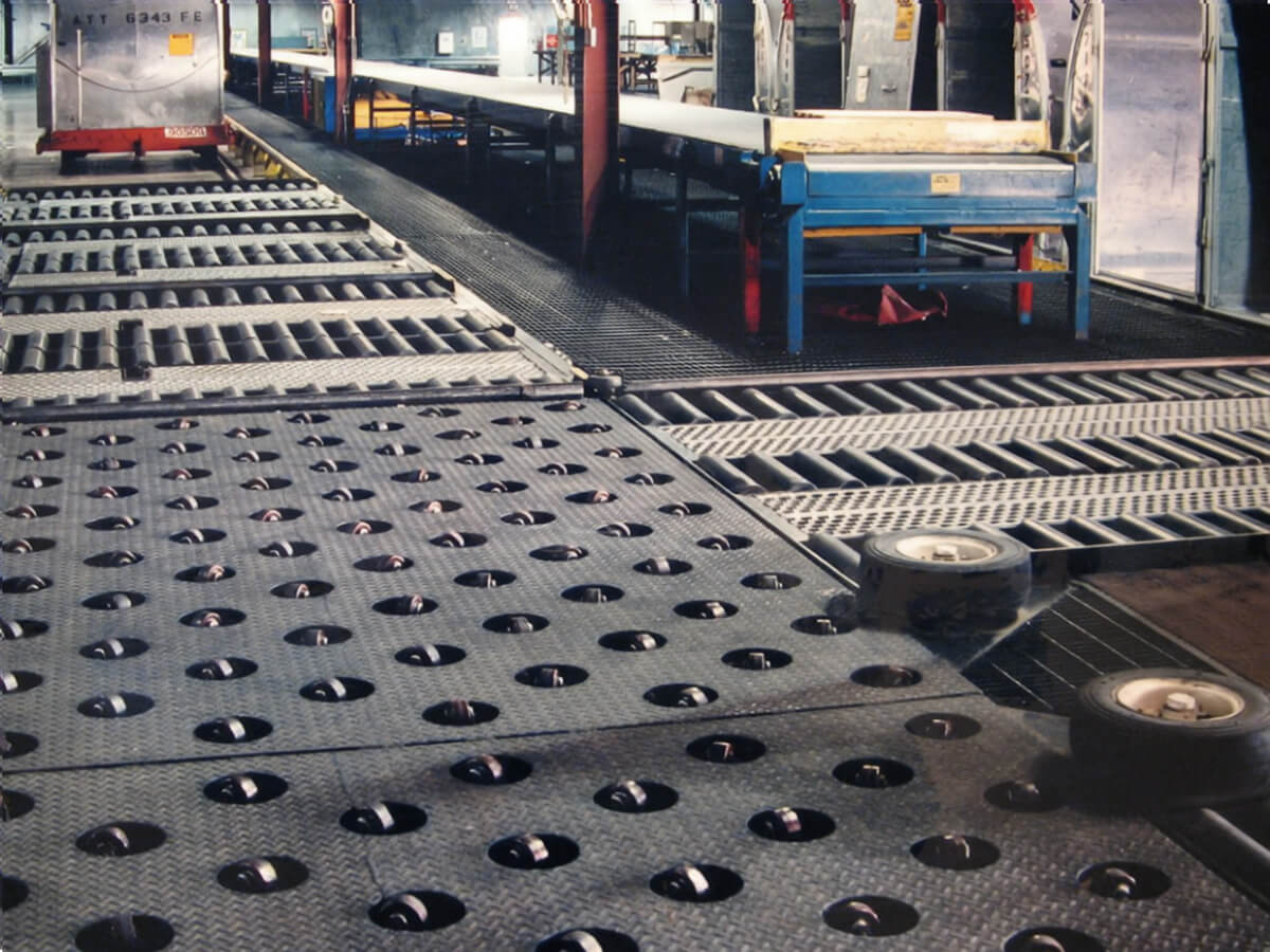 Ball transfer deck integrated with roller conveyor systems for manual load positioning and multi-directional movement.