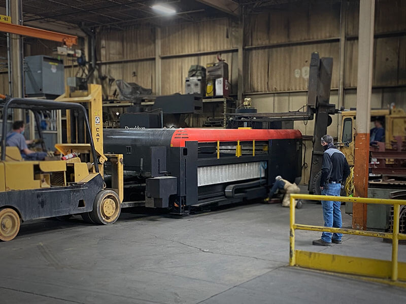 New industrial laser being delivered to Webb-Stiles Valley City facility with plant superintendent observing