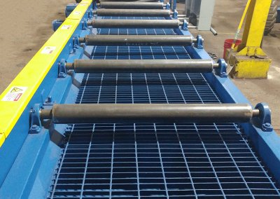 Chain driven live roller conveyor for shot blaster outfeed, moving weldments to Power and Free load position