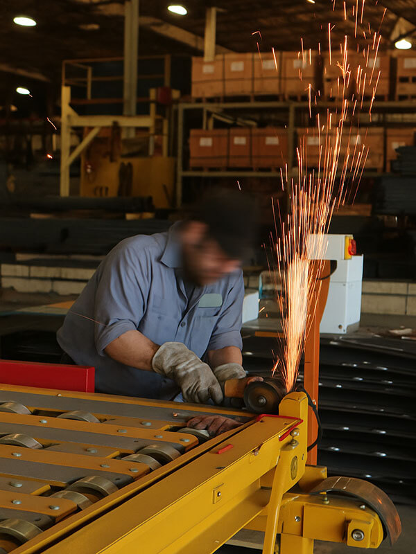 Welder working in fabrication shop, sparks flying from metalwork