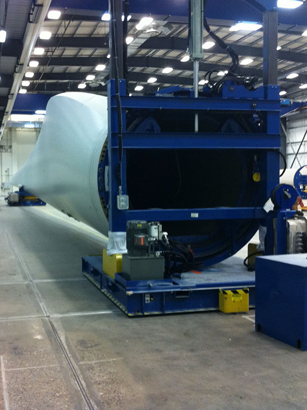 Root end of wind turbine blade on custom towline rotation system in manufacturing facility