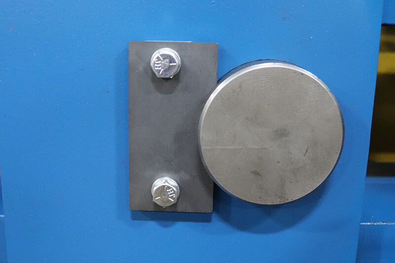 Steel keeper plate with two bolts securing a sprocket on a blue conveyor frame