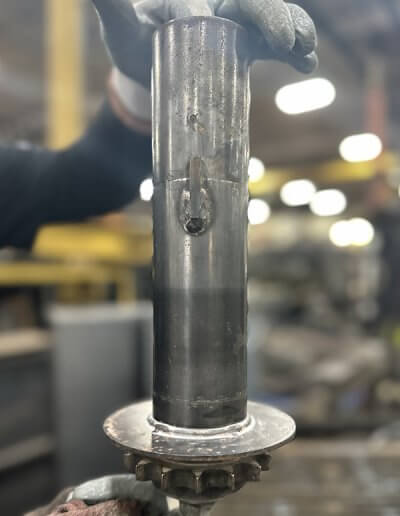 Custom vertical sprocketed roller designed for carousel use in robotic painting systems.