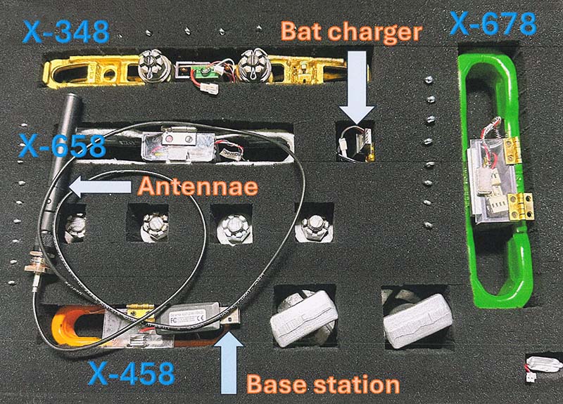 Overhead conveyor strain gauge testing kit with labeled chain links, antennae, battery charger, and base station.